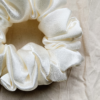 Cream Cloud ivory chunky scrunchie made from luxe charmeuse satin. Oversized design, approximately twice the size of a standard scrunchie, with a smooth, glossy finish that adds a touch of elegance and volume to any hairstyle.
