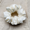 Cream Cloud ivory chunky scrunchie made from luxe charmeuse satin. Oversized design, approximately twice the size of a standard scrunchie, with a smooth, glossy finish that adds a touch of elegance and volume to any hairstyle.