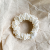 Cream Cloud ivory petite scrunchie made from luxe charmeuse satin. Oversized design, approximately twice the size of a standard scrunchie, with a smooth, glossy finish that adds a touch of elegance to any hairstyle.