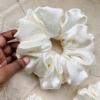 Cream Cloud XL scrunchie in ivory, made from luxurious charmeuse silk. Four times the size of the chunky scrunchie, this oversized scrunchie offers an extravagant, voluminous look with a smooth, glossy finish, perfect for making a bold statement or securing hair comfortably.