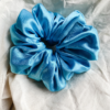 Blue Spark XL scrunchie in electric blue, made from luxurious charmeuse silk. Four times the size of the chunky scrunchie, this oversized scrunchie offers an extravagant, voluminous look with a smooth, glossy finish, perfect for making a bold statement or securing hair comfortably.