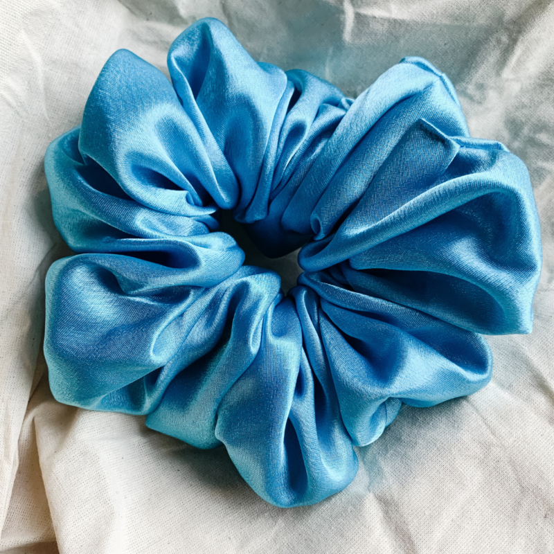 Blue Spark XL scrunchie in electric blue, made from luxurious charmeuse silk. Four times the size of the chunky scrunchie, this oversized scrunchie offers an extravagant, voluminous look with a smooth, glossy finish, perfect for making a bold statement or securing hair comfortably.