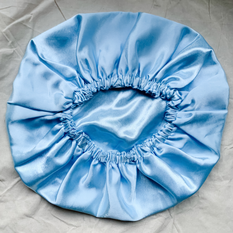 Blueberry baby blue bonnet made from luxe charmeuse satin. Oversized design, approximately twice the size of a standard scrunchie, with a smooth, glossy finish that adds a touch of elegance to any hairstyle.