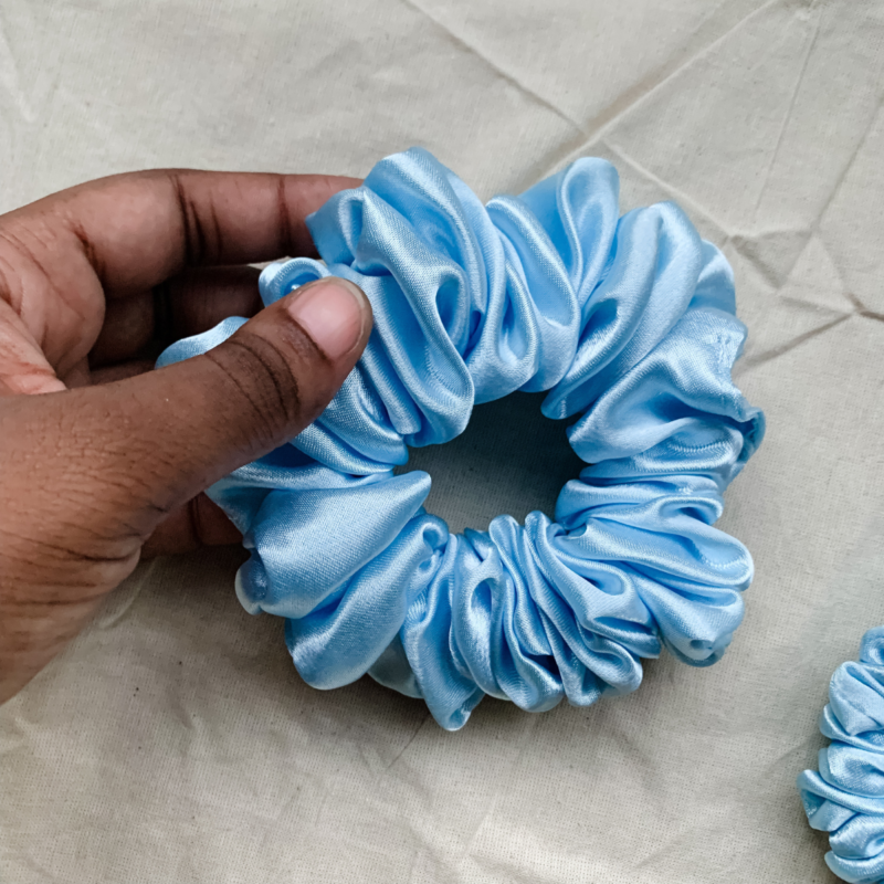 Blueberry baby blue chunky scrunchie made from luxe charmeuse satin. Oversized design, approximately twice the size of a standard scrunchie, with a smooth, glossy finish that adds a touch of elegance and volume to any hairstyle.