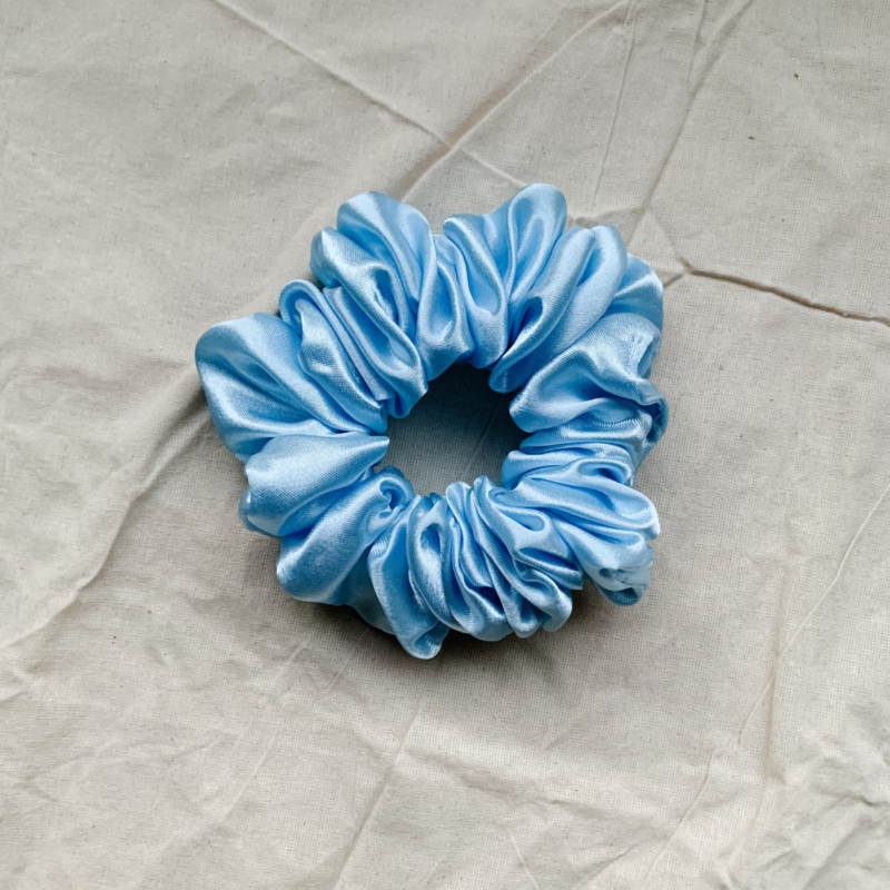 Blueberry baby blue chunky scrunchie made from luxe charmeuse satin. Oversized design, approximately twice the size of a standard scrunchie, with a smooth, glossy finish that adds a touch of elegance and volume to any hairstyle.