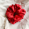Crimson Cheer christmas red chunky scrunchie made from luxe charmeuse satin. Oversized design, approximately twice the size of a standard scrunchie, with a smooth, glossy finish that adds a touch of elegance and volume to any hairstyle.