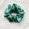 Evergreen Noel christmas green chunky scrunchie made from luxe charmeuse satin. Oversized design, approximately twice the size of a standard scrunchie, with a smooth, glossy finish that adds a touch of elegance and volume to any hairstyle.