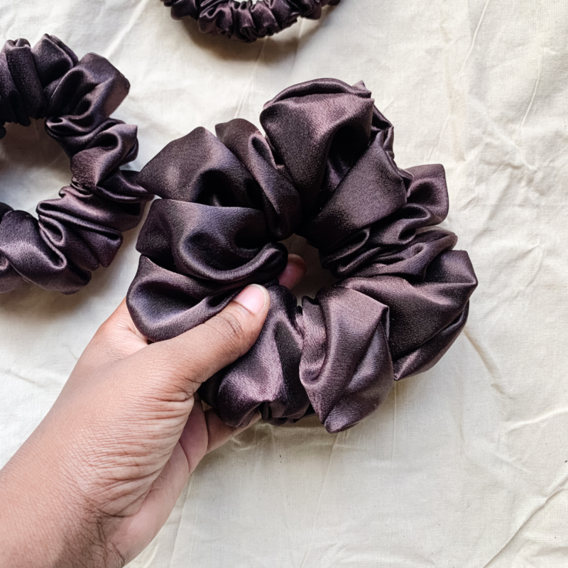 Fresh brew, coffee brown chunky scrunchie made from luxe charmeuse satin. Oversized design, approximately twice the size of a standard scrunchie, with a smooth, glossy finish that adds a touch of elegance and volume to any hairstyle.