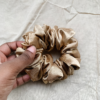 Golden Glow yellow toned gold chunky scrunchie made from luxe charmeuse satin. Oversized design, approximately twice the size of a standard scrunchie, with a smooth, glossy finish that adds a touch of elegance and volume to any hairstyle.