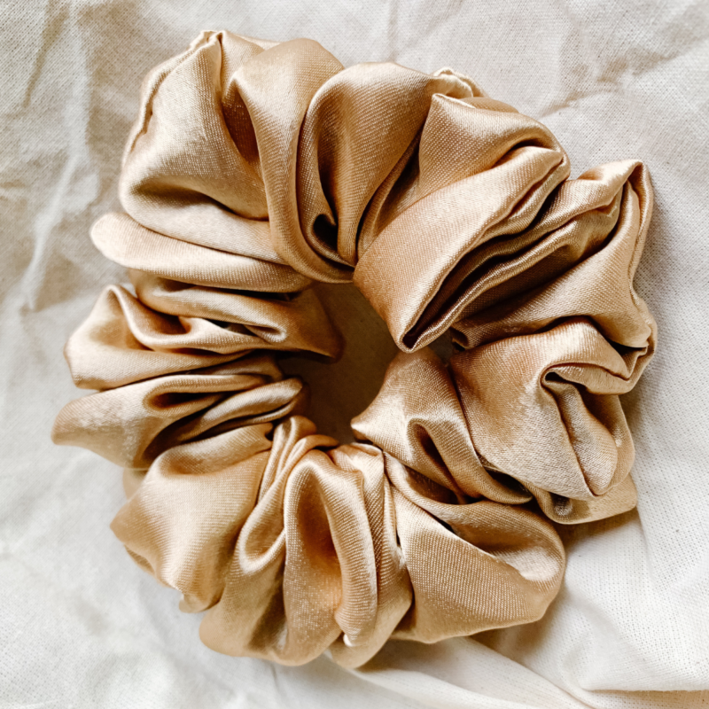 Golden Glow yellow toned gold chunky scrunchie made from luxe charmeuse satin. Oversized design, approximately twice the size of a standard scrunchie, with a smooth, glossy finish that adds a touch of elegance and volume to any hairstyle.