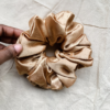 Golden Glow XL scrunchie in yellow toned gold, made from luxurious charmeuse silk. Four times the size of the chunky scrunchie, this oversized scrunchie offers an extravagant, voluminous look with a smooth, glossy finish, perfect for making a bold statement or securing hair comfortably.