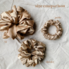 Golden Glow scrunchie comparison in yellow tone gold, showcasing three sizes: petite, chunky, and XL. The petite scrunchie offers a more delicate, subtle look, the chunky scrunchie adds bold volume, and the XL scrunchie, four times the size of the chunky, provides maximum volume and impact. All scrunchies are made from smooth, luxurious charmeuse silk for a glossy, elegant finish.