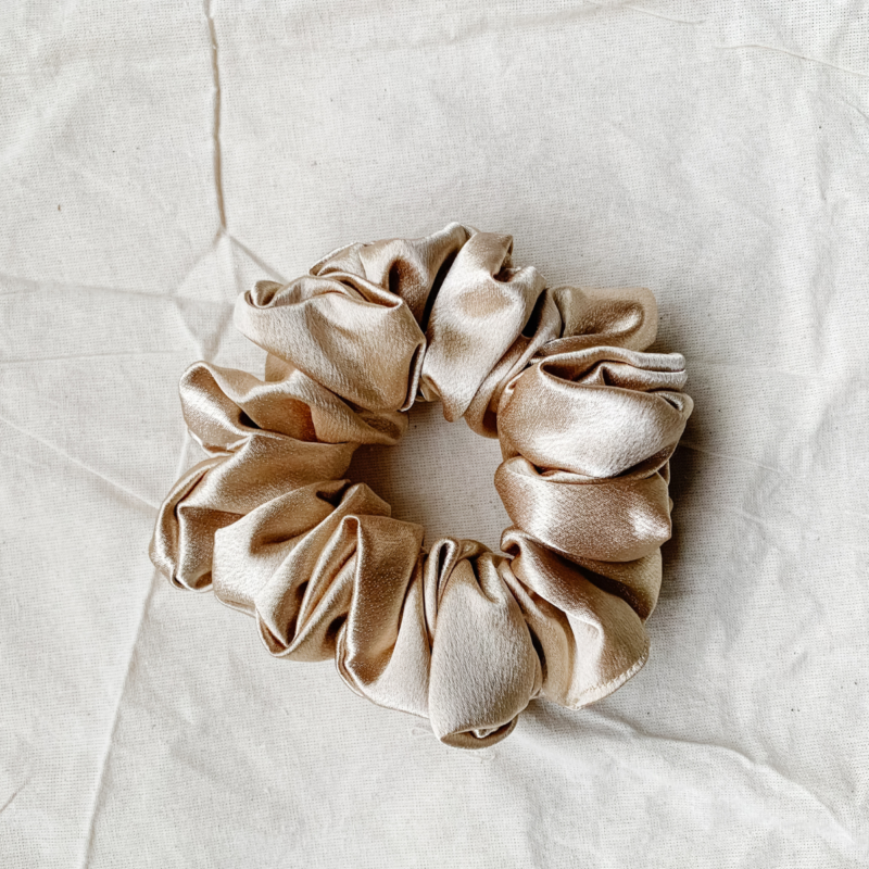 Golden Hour golden chunky scrunchie made from luxe charmeuse satin. Oversized design, approximately twice the size of a standard scrunchie, with a smooth, glossy finish that adds a touch of elegance and volume to any hairstyle.