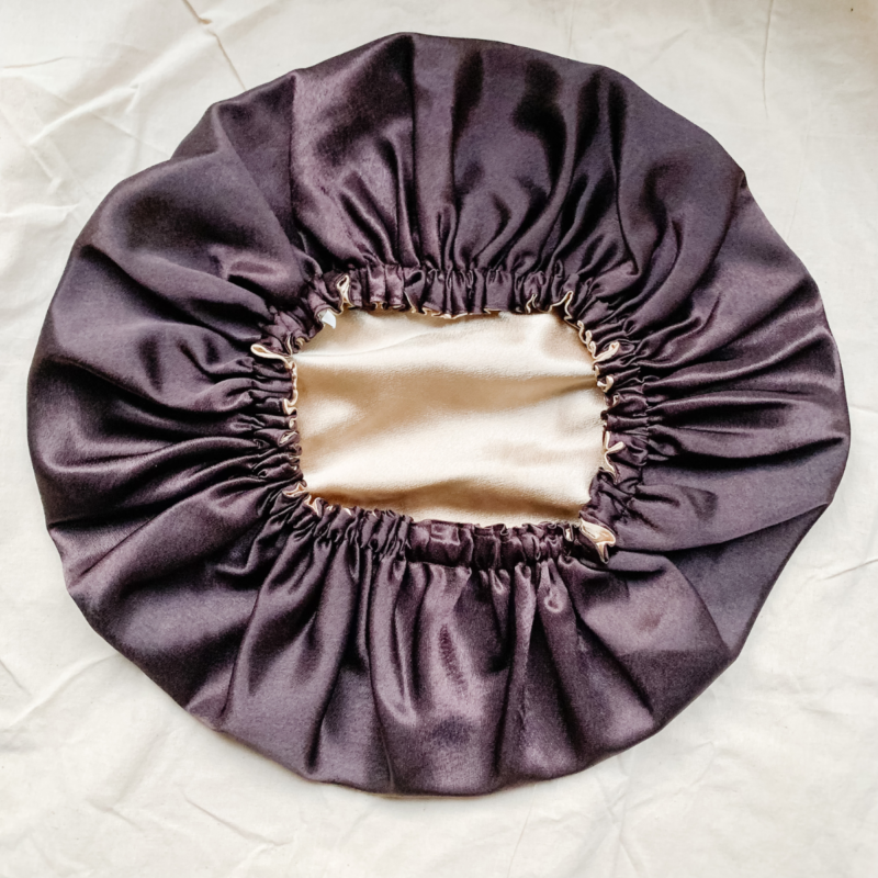 Golden Mocha reversible silk bonnet in coffee brown and gold. Made from smooth charmeuse silk, this bonnet features a comfortable elastic band for a secure fit, offering a soft, luxurious touch for protecting hair while sleeping or resting.