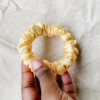 Honey Dew pale yellow petite scrunchie made from luxe charmeuse satin. Oversized design, approximately twice the size of a standard scrunchie, with a smooth, glossy finish that adds a touch of elegance to any hairstyle.