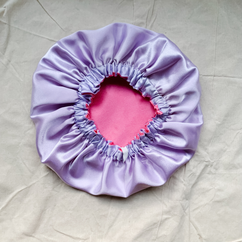 Lavender Blossom Silk Bonnet for Kids – Protects hair from frizz and moisture loss while sleeping. Made from soft charmeuse silk in lavender and rose pink, fits most children ages 2-6.