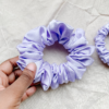 Lavender chunky scrunchie made from luxe charmeuse satin. Oversized design, approximately twice the size of a standard scrunchie, with a smooth, glossy finish that adds a touch of elegance and volume to any hairstyle.