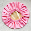 Lemonade Blush reversible silk bonnet in light yellow and light pink. Made from smooth charmeuse silk, this bonnet features a comfortable elastic band for a secure fit, offering a soft, luxurious touch for protecting hair while sleeping or resting.