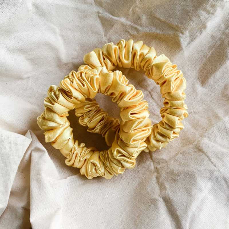 Lemonade yellow petite scrunchie made from luxe charmeuse satin. Oversized design, approximately twice the size of a standard scrunchie, with a smooth, glossy finish that adds a touch of elegance to any hairstyle.