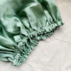 Matcha sage green bonnet made from luxe charmeuse satin. Oversized design, approximately twice the size of a standard scrunchie, with a smooth, glossy finish that adds a touch of elegance and volume to any hairstyle.