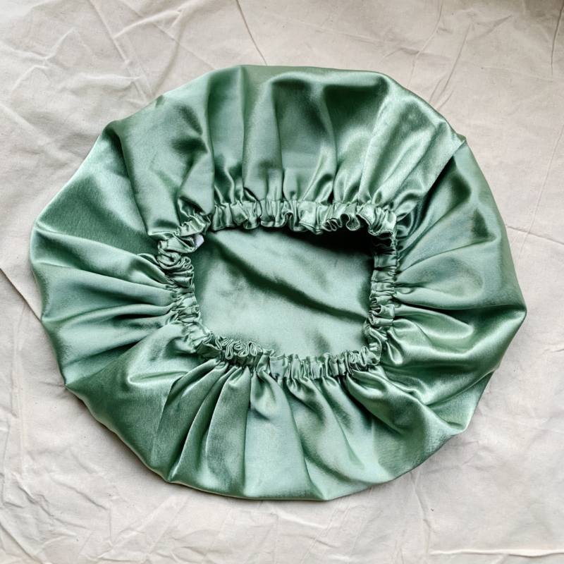 Matcha sage green bonnet made from luxe charmeuse satin. Oversized design, approximately twice the size of a standard scrunchie, with a smooth, glossy finish that adds a touch of elegance and volume to any hairstyle.