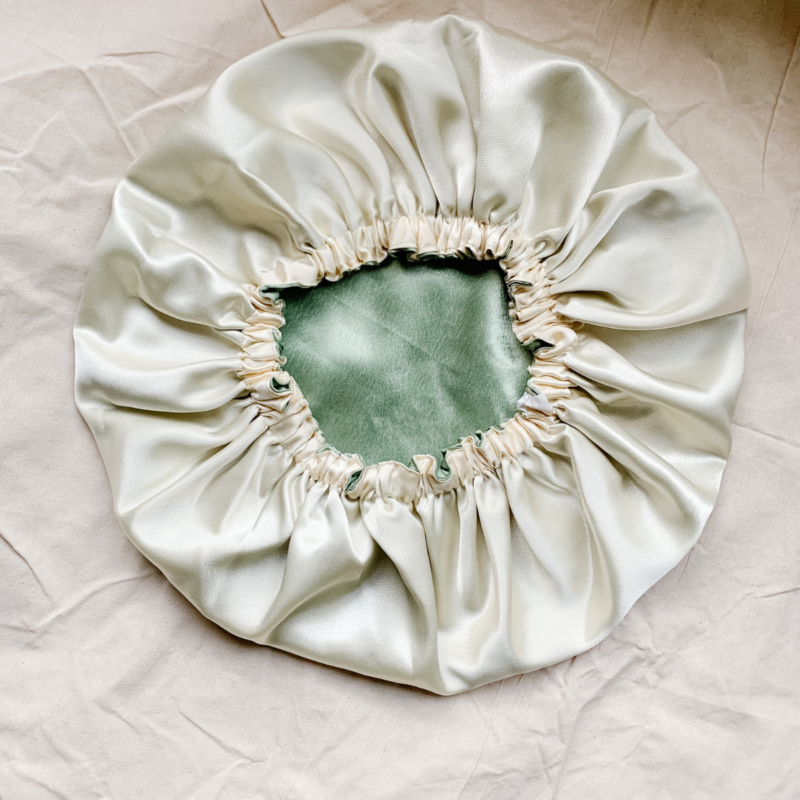 Matcha Latte reversible silk bonnet in sage green and cream . Made from smooth charmeuse silk, this bonnet features a comfortable elastic band for a secure fit, offering a soft, luxurious touch for protecting hair while sleeping or resting.