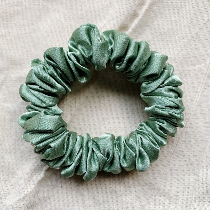 Matcha soft sage green Matcha soft sage green petite scrunchie made from luxe charmeuse satin. Oversized design, approximately twice the size of a standard scrunchie, with a smooth, glossy finish that adds a touch of elegance to any hairstyle.