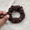 Melanin Magic deep brown scrunchie made from luxe charmeuse satin. Oversized design, approximately twice the size of a standard scrunchie, with a smooth, glossy finish that adds a touch of elegance to any hairstyle.