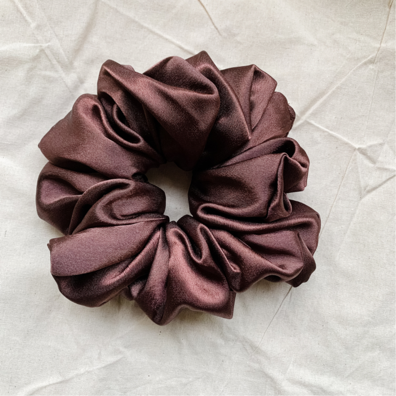 Melanin Magic deep brown scrunchie made from luxe charmeuse satin. Oversized design, approximately twice the size of a standard scrunchie, with a smooth, glossy finish that adds a touch of elegance and volume to any hairstyle.