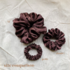 Melanin Magic Scrunchie comparison in deep brown, showcasing two sizes: petite, chunky. The petite scrunchie offers a more delicate, subtle look, the chunky scrunchie adds bold volume. All scrunchies are made from smooth, luxurious charmeuse silk for a glossy, elegant finish.