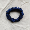 Midnight Tide navy blue petite scrunchie made from luxe charmeuse satin. Oversized design, approximately twice the size of a standard scrunchie, with a smooth, glossy finish that adds a touch of elegance to any hairstyle.