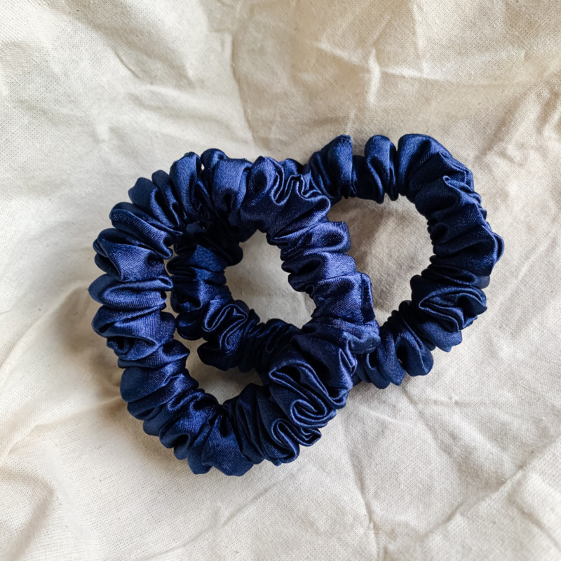 Midnight Tide navy blue petite scrunchie made from luxe charmeuse satin. Oversized design, approximately twice the size of a standard scrunchie, with a smooth, glossy finish that adds a touch of elegance to any hairstyle.