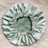 inMinted Matcha Latte reversible silk bonnet in frosted mint green and sage green . Made from smooth charmeuse silk, this bonnet features a comfortable elastic band for a secure fit, offering a soft, luxurious touch for protecting hair while sleeping or resting