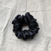 Noir black chunky scrunchie made from luxe charmeuse satin. Oversized design, approximately twice the size of a standard scrunchie, with a smooth, glossy finish that adds a touch of elegance and volume to any hairstyle.