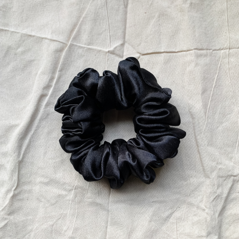 Noir black chunky scrunchie made from luxe charmeuse satin. Oversized design, approximately twice the size of a standard scrunchie, with a smooth, glossy finish that adds a touch of elegance and volume to any hairstyle.