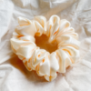 Oat milk cream chunky scrunchie made from luxe charmeuse satin. Oversized design, approximately twice the size of a standard scrunchie, with a smooth, glossy finish that adds a touch of elegance and volume to any hairstyle.