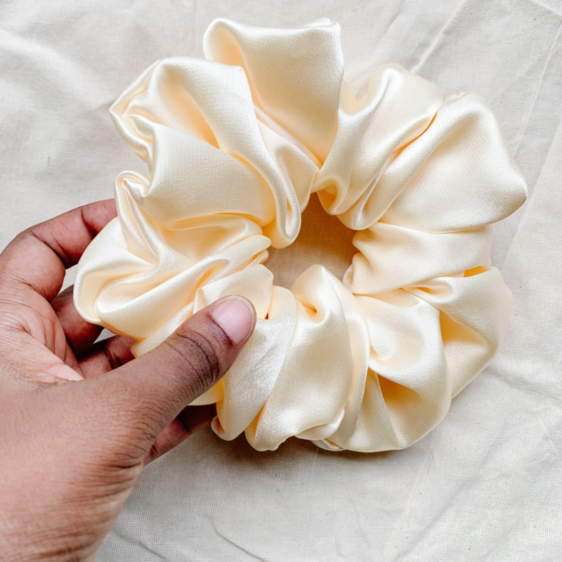 Oatmilk cream xl scrunchie made from luxe charmeuse satin. Oversized design, approximately twice the size of a standard scrunchie, with a smooth, glossy finish that adds a touch of elegance and volume to any hairstyle.