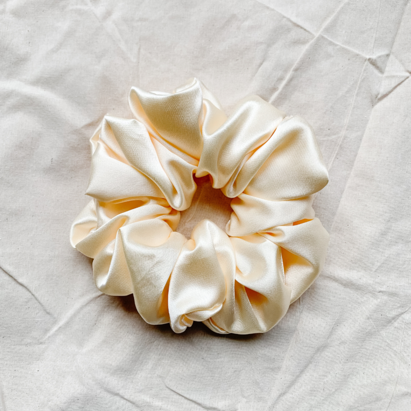 Oatmilk cream xl scrunchie made from luxe charmeuse satin. Oversized design, approximately twice the size of a standard scrunchie, with a smooth, glossy finish that adds a touch of elegance and volume to any hairstyle.