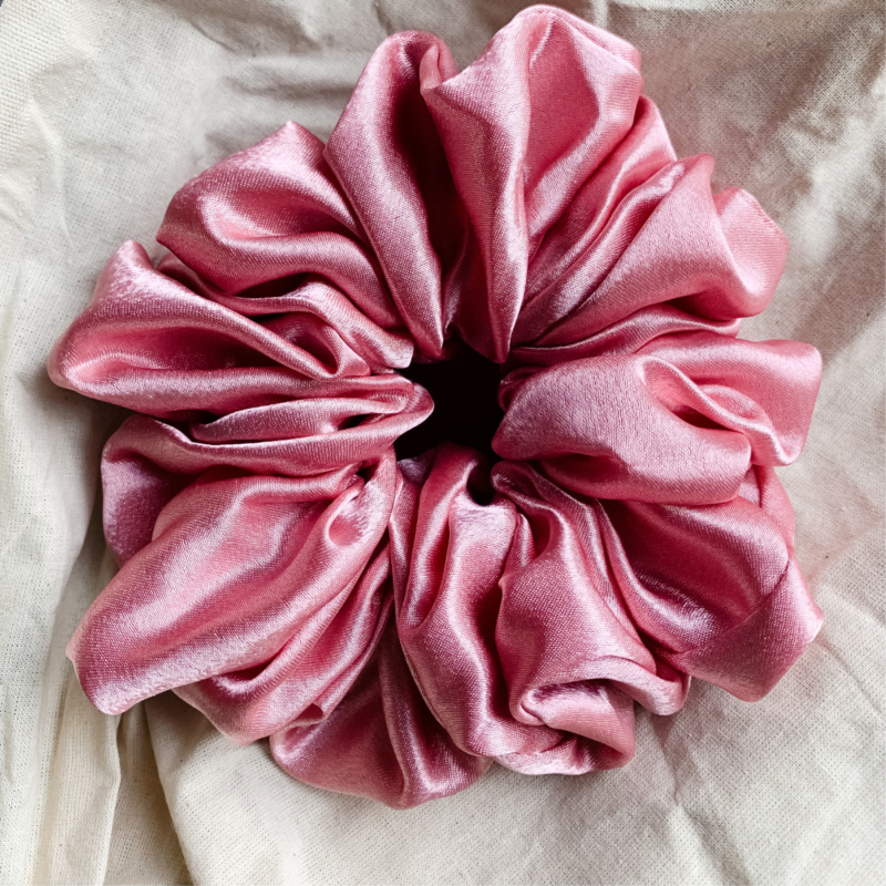 Peach Fizz XL scrunchie in peachy pink, made from luxurious charmeuse silk. Four times the size of the chunky scrunchie, this oversized scrunchie offers an extravagant, voluminous look with a smooth, glossy finish, perfect for making a bold statement or securing hair comfortably.