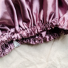 Rosé Glow reversible silk bonnet in metallic mauve. Made from smooth charmeuse silk, this bonnet features a comfortable elastic band for a secure fit, offering a soft, luxurious touch for protecting hair while sleeping or resting.