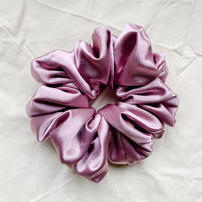 Rosé Glow XL scrunchie in metallic mauve, made from luxurious charmeuse silk. Four times the size of the chunky scrunchie, this oversized scrunchie offers an extravagant, voluminous look with a smooth, glossy finish, perfect for making a bold statement or securing hair comfortably.