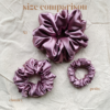 Rosé Glow scrunchie comparison in metallic mauve, showcasing three sizes: petite, chunky, and XL. The petite scrunchie offers a more delicate, subtle look, the chunky scrunchie adds bold volume, and the XL scrunchie, four times the size of the chunky, provides maximum volume and impact. All scrunchies are made from smooth, luxurious charmeuse silk for a glossy, elegant finish.