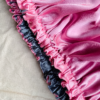 Silver Rose reversible silk bonnet in silver and light pink. Made from smooth charmeuse silk, this bonnet features a comfortable elastic band for a secure fit, offering a soft, luxurious touch for protecting hair while sleeping or resting.