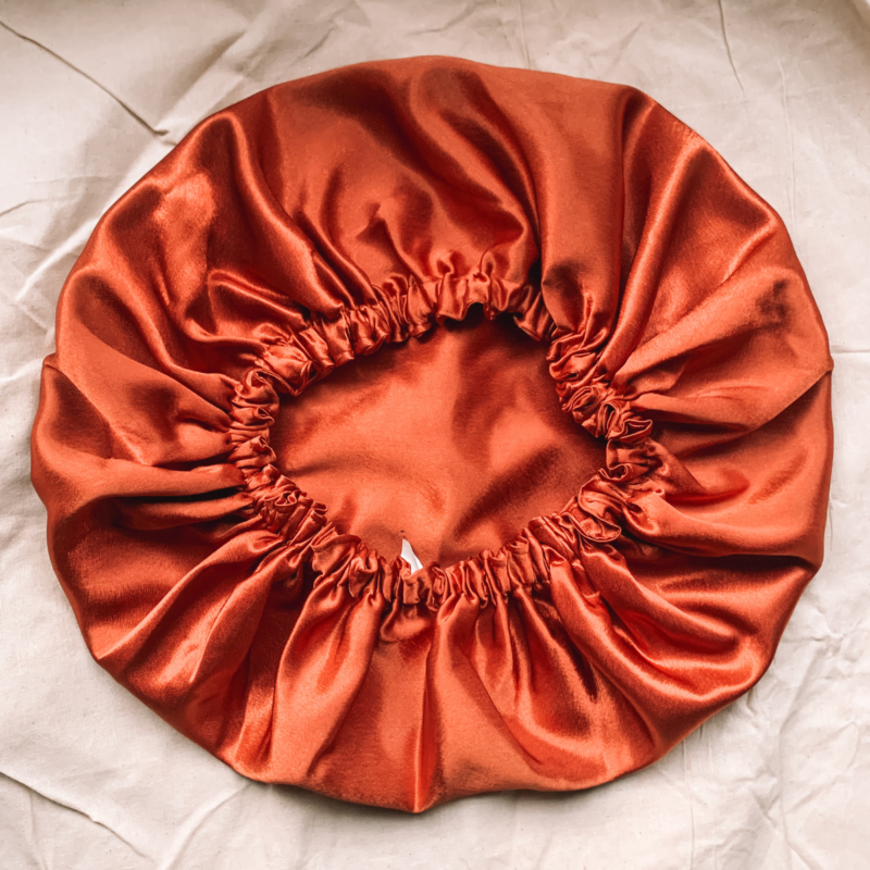 Sunset Glow terracotta bonnet made from luxe charmeuse satin. Oversized design, approximately twice the size of a standard scrunchie, with a smooth, glossy finish that adds a touch of elegance to any hairstyle.