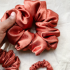 Sunset Glow terracotta xl scrunchie made from luxe charmeuse satin. Oversized design, approximately twice the size of a standard scrunchie, with a smooth, glossy finish that adds a touch of elegance and volume to any hairstyle.
