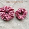 Peach Fizz Scrunchie comparison in peachy pink, showcasing two sizes: petite, chunky. The petite scrunchie offers a more delicate, subtle look, the chunky scrunchie adds bold volume. All scrunchies are made from smooth, luxurious charmeuse silk for a glossy, elegant finish.