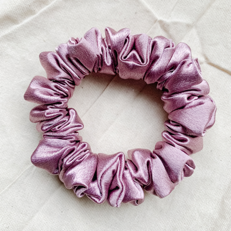 close up view of our rosรฉ petite scrunchie, mauve satin scrunchie, ouchless hair tie