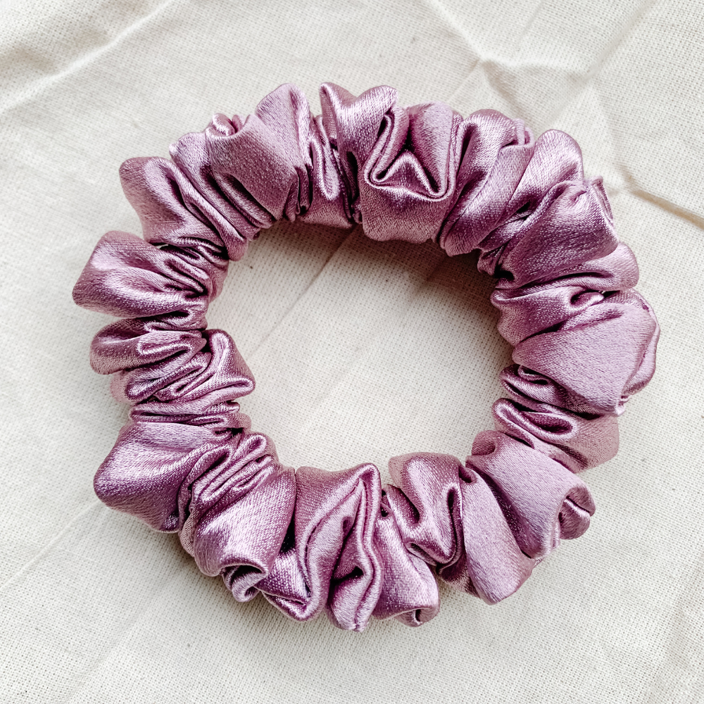 close up view of our rosé petite scrunchie, mauve satin scrunchie, ouchless hair tie